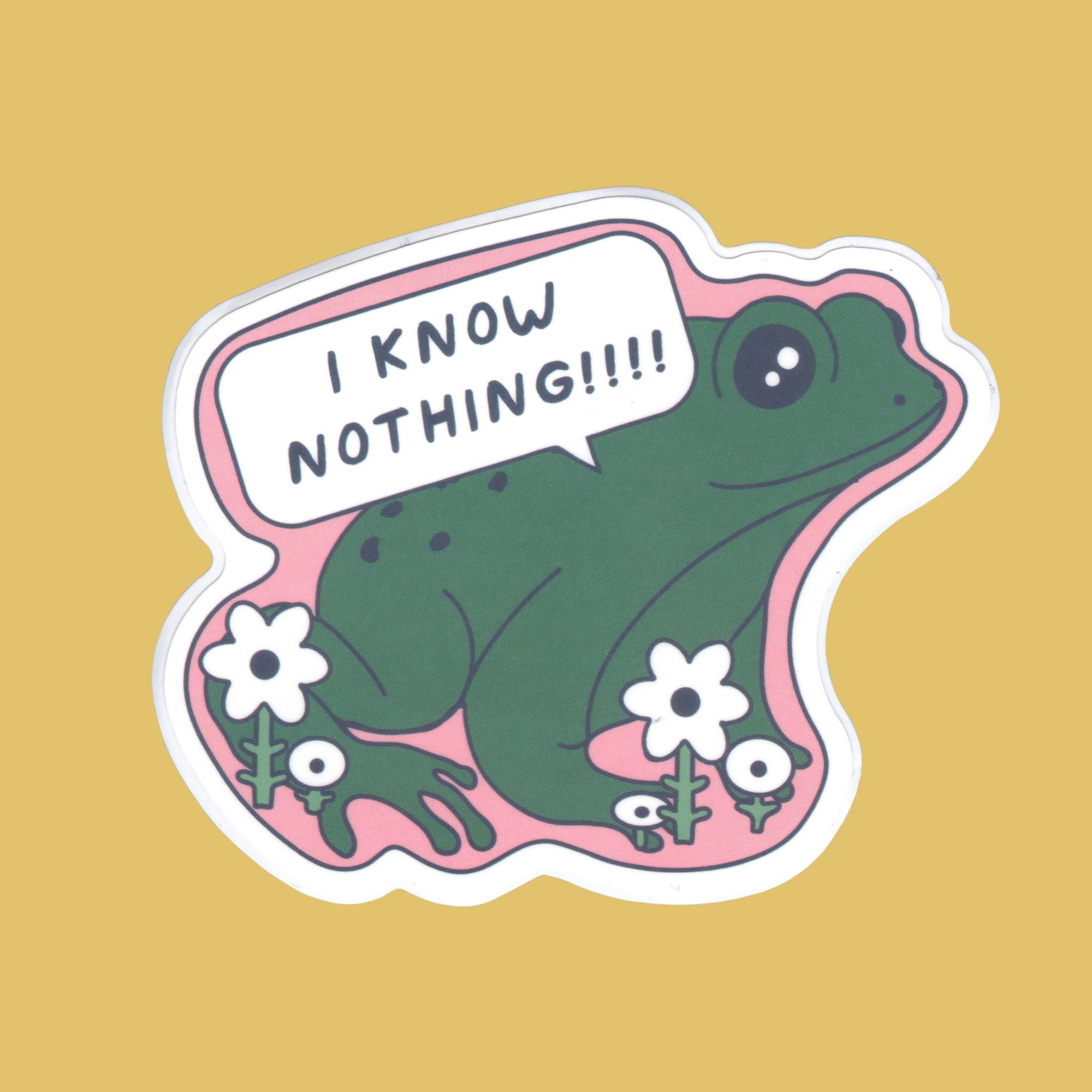 A die-cut sticker featuring a green cartoon frog sitting on pink grass with white flowers and a speech bubble that says 'I KNOW NOTHING!!!!', shown on a solid mustard yellow background.